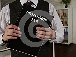 CITIZENSHIP LAW book in the hands of a lawyer. Citizenship law is theÂ lawÂ of a sovereign state, and of each of its